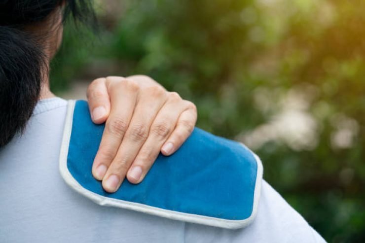 woman putting an ice pack on her shoulder pain